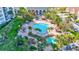 An aerial view of a community pool, complete with lounge seating, shaded tables, and lush landscaping at 400 Island Way # 201, Clearwater Beach, FL 33767