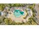 Overhead shot of a sparkling pool and hot tub surrounded by lounge chairs and tiki umbrellas at 400 Island Way # 201, Clearwater Beach, FL 33767