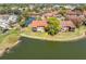 Aerial view of home with balconies overlooking a serene lake in a lush neighborhood at 4027 Davit Dr, New Port Richey, FL 34652