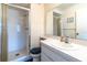 Bright bathroom with a walk-in shower, white tile, and a large mirror above the vanity with a solid surface countertop at 4027 Davit Dr, New Port Richey, FL 34652