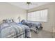 Cozy bedroom featuring two twin beds with blue and white bedding, a ceiling fan, and a window for natural light at 4027 Davit Dr, New Port Richey, FL 34652
