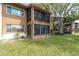 Back of a condo featuring a screened lanai, lush lawn, and mature trees at 4027 Davit Dr, New Port Richey, FL 34652