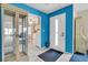 Bright foyer with blue accent wall, white trim, and tile floor flowing to the kitchen at 4027 Davit Dr, New Port Richey, FL 34652