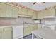Cozy kitchen with white appliances, light-colored cabinets and tile backsplash at 4027 Davit Dr, New Port Richey, FL 34652
