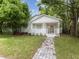 Charming home with a brick walkway, front porch, manicured lawn, and mature trees at 445 33Rd N Ave, St Petersburg, FL 33704