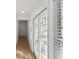 Hallway with wood floors leads past bright french doors and window with blinds at 445 33Rd N Ave, St Petersburg, FL 33704