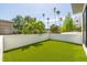 Private backyard featuring artificial turf, surrounded by walls and lush palm trees, perfect for relaxation at 4515 W North A St # 8, Tampa, FL 33609