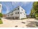 Modern townhome featuring a white facade, attached garage, and well-manicured landscaping against a sunny sky at 4515 W North A St # 8, Tampa, FL 33609