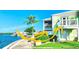 Bright exterior view of a waterfront home with two balconies overlooking lush landscaping and water at 5285 Coquina Key Se Dr # C, St Petersburg, FL 33705