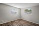 Cozy bedroom with neutral walls, wood-look flooring, and natural light from two windows at 5300 6Th S Ave, St Petersburg, FL 33707