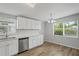Updated kitchen with stainless steel appliances, white cabinetry, and new wood flooring at 5300 6Th S Ave, St Petersburg, FL 33707