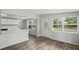 Open-concept living space with wood flooring and a view of the front door and kitchen area at 5300 6Th S Ave, St Petersburg, FL 33707
