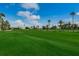 Expansive golf course with lush green fairways, palm trees, and community buildings in the distance at 6073 Bahia Del Mar Blvd # 129, St Petersburg, FL 33715