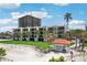Condominium exterior shows lush landscaping and sandy beach with beautiful blue sky and a gazebo for relaxing and enjoying the views at 7564 Bayshore Dr # 306, Treasure Island, FL 33706