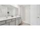 Bright bathroom with double sinks, white cabinets, and a separate shower area at 7770 Wheat Stone Dr, Zephyrhills, FL 33540