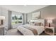Comfortable bedroom with a large window overlooking the backyard and neutral-toned decor at 7770 Wheat Stone Dr, Zephyrhills, FL 33540