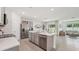 Open kitchen with a large island, stainless steel appliances, and a view of the living area at 7770 Wheat Stone Dr, Zephyrhills, FL 33540