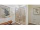 Tiled shower showcasing modern bathroom design, complemented by tasteful artwork and a comfortable bench at 7775 Wheat Stone Dr, Zephyrhills, FL 33540