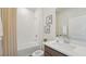 Clean bathroom featuring a shower-tub combo, neutral tiles, and modern fixtures at 7775 Wheat Stone Dr, Zephyrhills, FL 33540