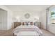 Inviting bedroom features paneled wall, a comfortable bed, bench seat and large window with natural light at 7775 Wheat Stone Dr, Zephyrhills, FL 33540