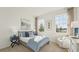 Bright bedroom with large windows, a cozy chair, and neutral decor at 7775 Wheat Stone Dr, Zephyrhills, FL 33540