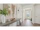 Inviting entryway with wood floors, console table, and stylish decor leading to the living area at 7775 Wheat Stone Dr, Zephyrhills, FL 33540