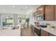 Modern kitchen with an island, stainless appliances, and a view into the dining area at 7775 Wheat Stone Dr, Zephyrhills, FL 33540