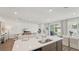 Open-concept living space with kitchen island, recessed lighting, and a view to the backyard at 7775 Wheat Stone Dr, Zephyrhills, FL 33540