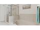Bright bathroom features a soaking tub and glass shower with serene beach-themed decor at 7903 Seminole Blvd # 2204, Seminole, FL 33772