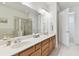 Bathroom featuring double sinks, wooden cabinets, and a glass-enclosed shower at 7903 Seminole Blvd # 2204, Seminole, FL 33772