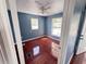 Cozy bedroom featuring wood-look flooring and natural light from two windows at 804 Whitehurst Rd, Plant City, FL 33563