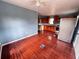 Open-concept living and kitchen space, showcasing rich red flooring and a ceiling fan, illuminated by natural light at 804 Whitehurst Rd, Plant City, FL 33563