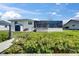 Back exterior view features lush greenery, a private dock, and a screened-in lanai for outdoor enjoyment at 829 Golf Island Dr, Apollo Beach, FL 33572