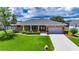 Charming brick home with a well-maintained lawn, long driveway and beautiful garden at 829 Golf Island Dr, Apollo Beach, FL 33572