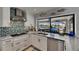 Well-lit kitchen features granite countertops, stainless steel appliances and sink, and decorative backsplash at 829 Golf Island Dr, Apollo Beach, FL 33572