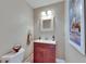 This powder room features a single sink vanity with decorative mirror and fixtures, plus toilet at 829 Golf Island Dr, Apollo Beach, FL 33572