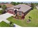 Aerial view of a well-maintained single-story house with lush green lawn, landscaping, and a two-car garage at 8437 White Poplar Dr, Riverview, FL 33578