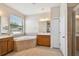 Bathroom with a soaking tub, tile floor, and separate vanity areas at 8437 White Poplar Dr, Riverview, FL 33578