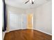 A cozy bedroom with hardwood floors, a ceiling fan, and a double door closet at 8437 White Poplar Dr, Riverview, FL 33578