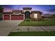 Stunning home featuring a three-car garage, manicured lawn, and beautiful plants and shrubbery at 8437 White Poplar Dr, Riverview, FL 33578