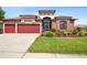 Charming single-story home featuring a well-manicured lawn, mature landscaping, and a two-car garage at 8437 White Poplar Dr, Riverview, FL 33578