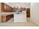 Spacious kitchen boasts wood cabinetry, tile floors, and modern lighting at 8437 White Poplar Dr, Riverview, FL 33578