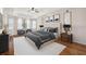 This primary bedroom features neutral decor, tray ceilings and hardwood floors at 8437 White Poplar Dr, Riverview, FL 33578
