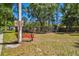Community playground has a red bench and posted rules, enclosed by a chain-link fence, among a grassy area at 8437 White Poplar Dr, Riverview, FL 33578