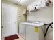 Practical laundry room equipped with a washer, dryer, and storage shelving at 9954 N Jasmine Brook E Cir, Land O Lakes, FL 34638