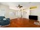Open living room with hardwood floors, light walls, and a ceiling fan with a view to the kitchen at 9954 N Jasmine Brook E Cir, Land O Lakes, FL 34638