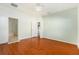 Bright main bedroom featuring hardwood floors, ensuite bathroom, and a ceiling fan at 9954 N Jasmine Brook E Cir, Land O Lakes, FL 34638