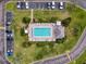Aerial view of a community pool with ample seating, lush greenery, and convenient guest parking at 110 W Cypress Ct, Oldsmar, FL 34677