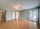 Spacious bedroom with hardwood floors, a ceiling fan, and access to the bathroom and patio at 110 W Cypress Ct, Oldsmar, FL 34677