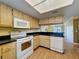 Bright kitchen features solid surface countertops, white appliances, and wood cabinets at 110 W Cypress Ct, Oldsmar, FL 34677